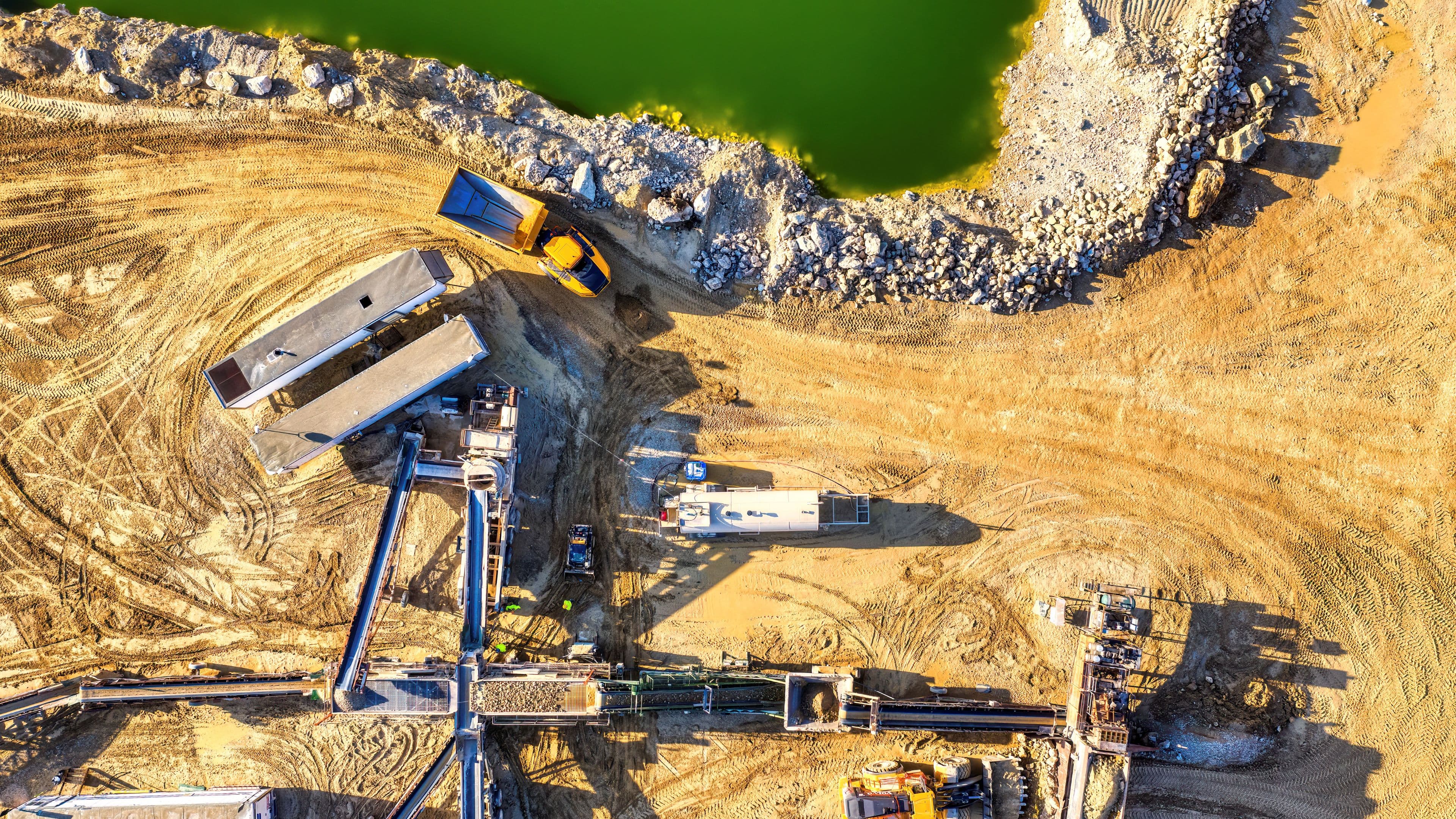 Aerial view of an open-pit mine with trucks and processing equipment